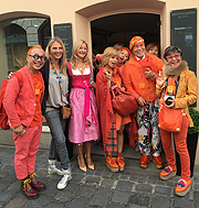 Überraschender Besuch von japanischen Frisören bei Heinzelmann: die beatunten die Dirndl, wir deren oranges Outfit